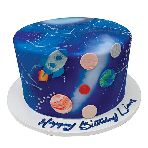 Space themed birthday cake with blue cream cheese frosting decorated with  gingerbread cookies in the shape of spaceship and planets on white  background Stock Photo | Adobe Stock